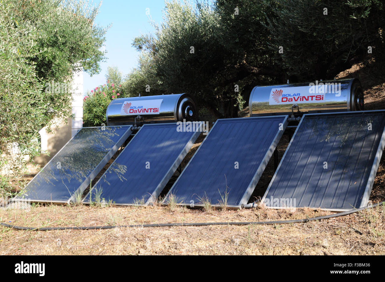 Solar water heaters on the ground beside a house in the small Greek village of Giolova in the Peloponnese. Stock Photo