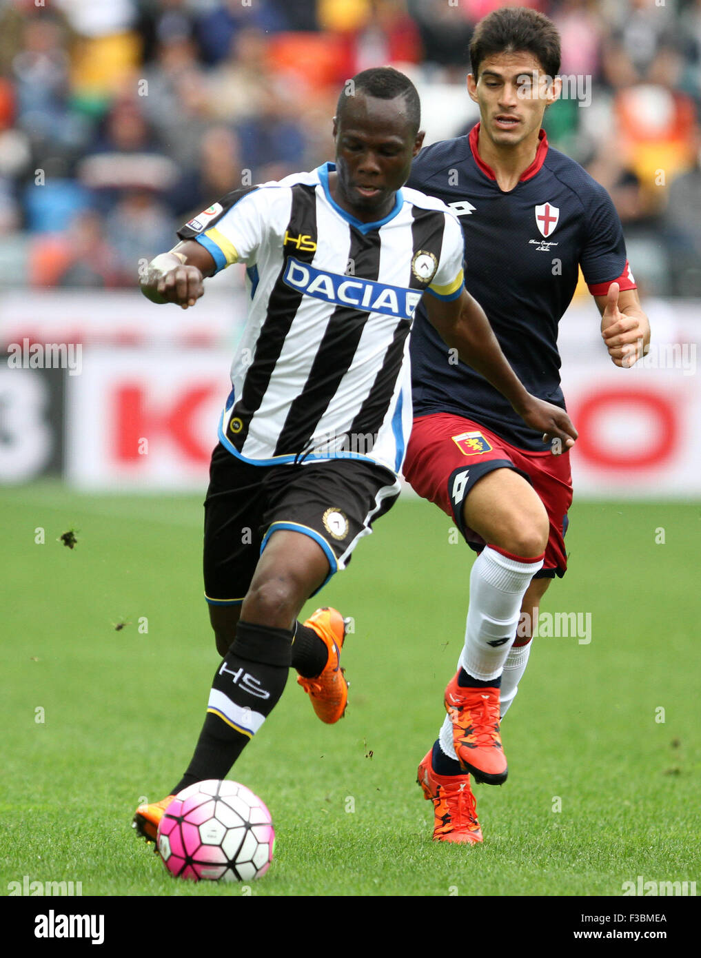 Udine, Italy. 4th October, 2015. Udinese's midfielder Emmanuel Agyemang Badu runs with balls behind Genoa's midfielder Diego Perotti follow him during the Italian Serie A football match between Udinese Calcio v Genoa Cfc at Friuli Stadium on 4 October, 2015 at Udine. Credit:  Andrea Spinelli/Alamy Live News Stock Photo