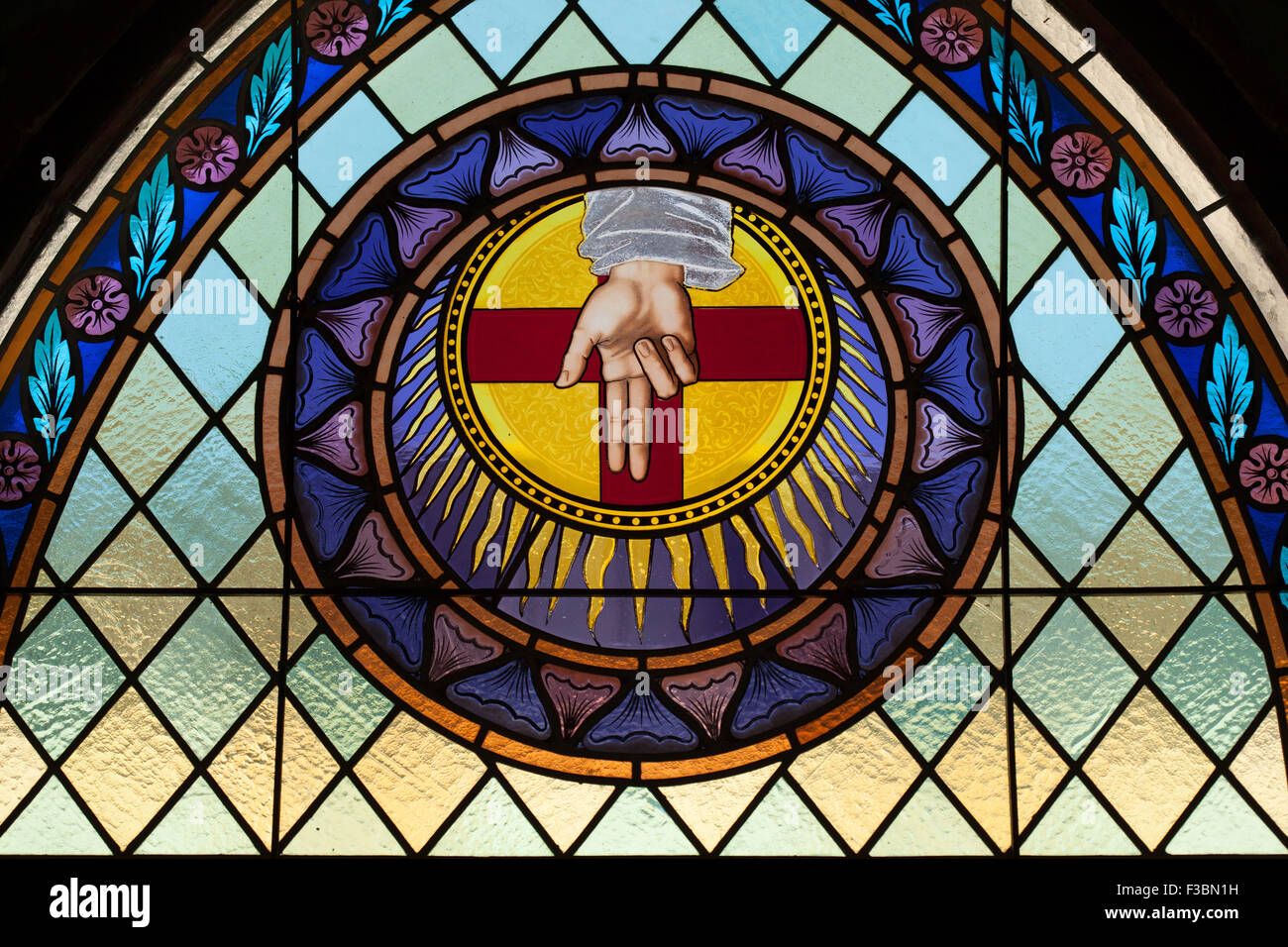 God the Father depicted as the Blessing Hand in the stained glass window by the Beuron Art School from the 1910s over the main e Stock Photo