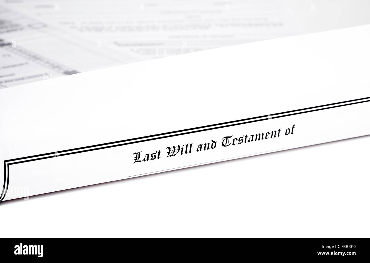 Last Will and Testament rolled up with advance health care directive and tax return in shallow depth of field isolated on white Stock Photo