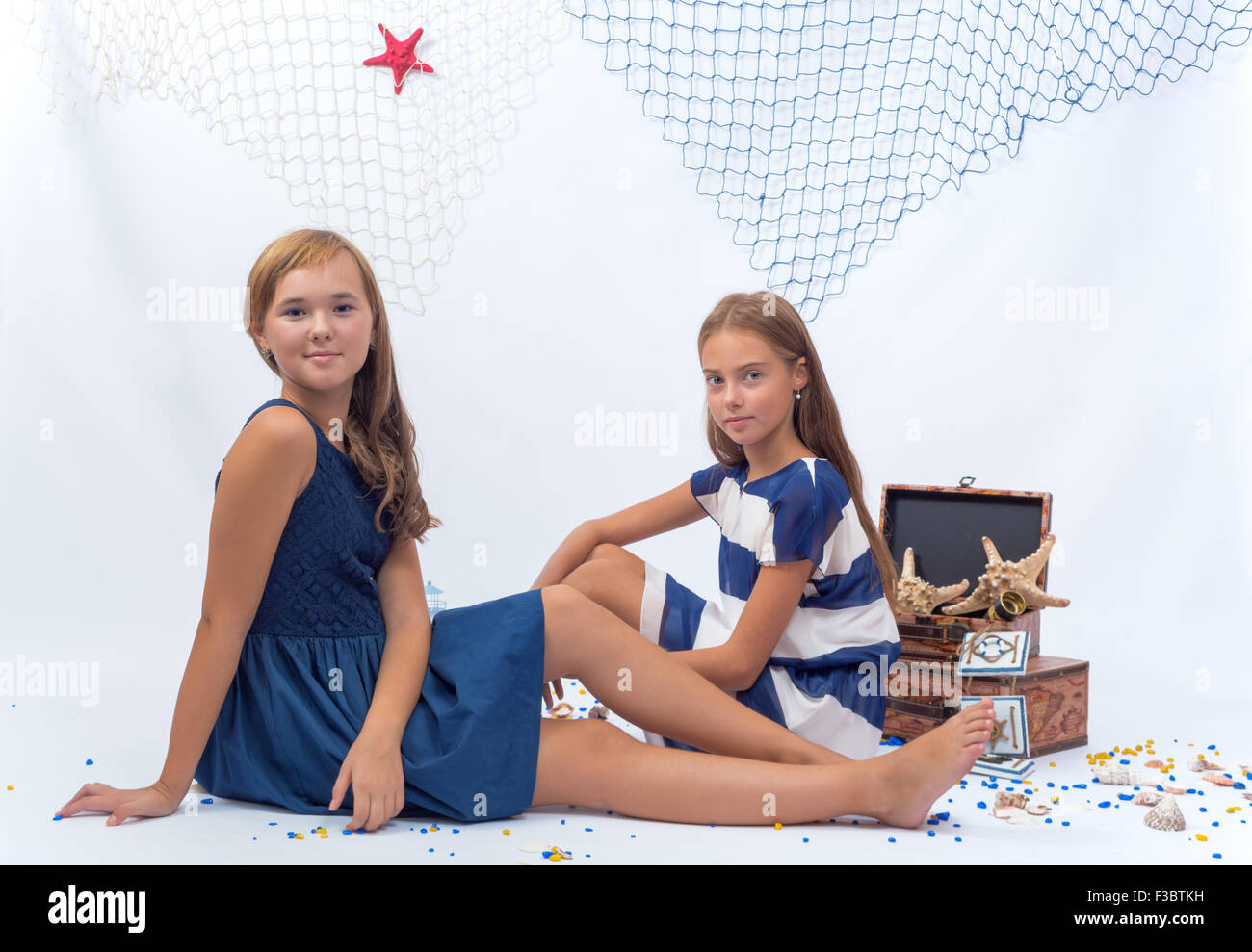 Two beautiful teen girls sitting on the floor Stock Photo - Alamy