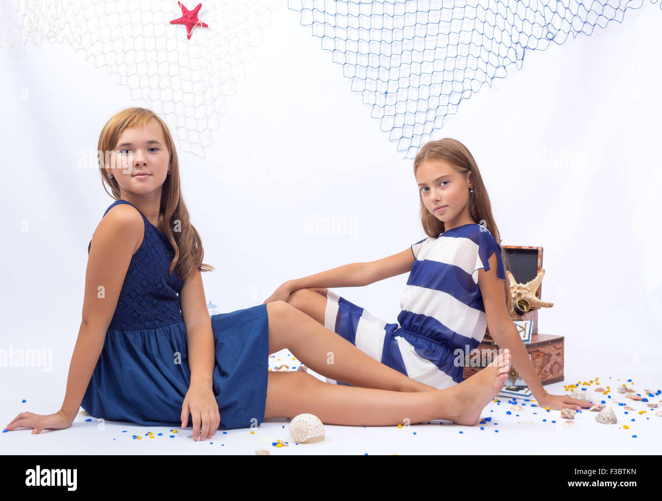 Two beautiful teen girls sitting on the floor marine style Stock Photo ...