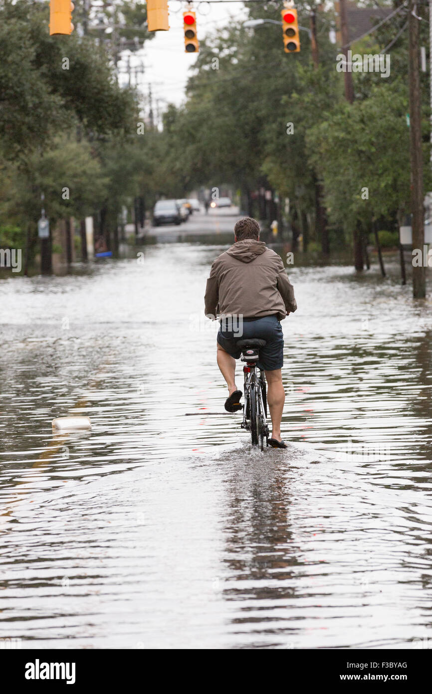 Charleston, South Carolina, USA. 4th October, 2015. A man rides his bicycle through floodwaters on Rutledge Avenue as severe flooding continued for the second day in the historic district as Hurricane Joaquin brings heavy rain, flooding and strong winds as it passes offshore October 4, 2015 in Charleston, South Carolina. Stock Photo