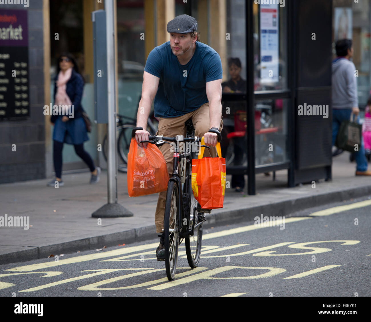 London, UK. 04 October, 2015. A cyclist carries one plastic carrier