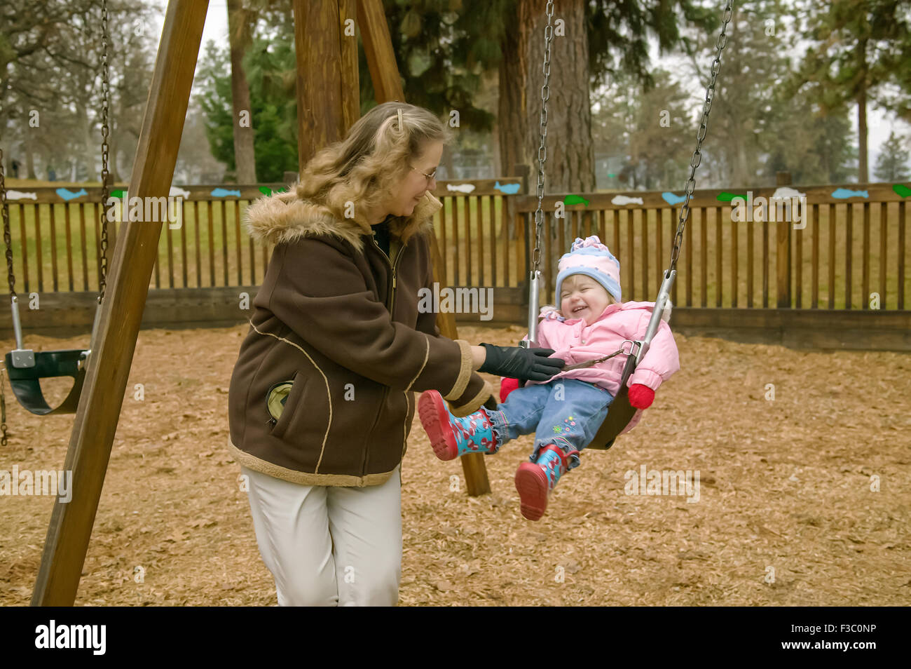 Woman pushing two year old girl in a swing, in The Dalles, Oregon, USA Stock Photo Alamy