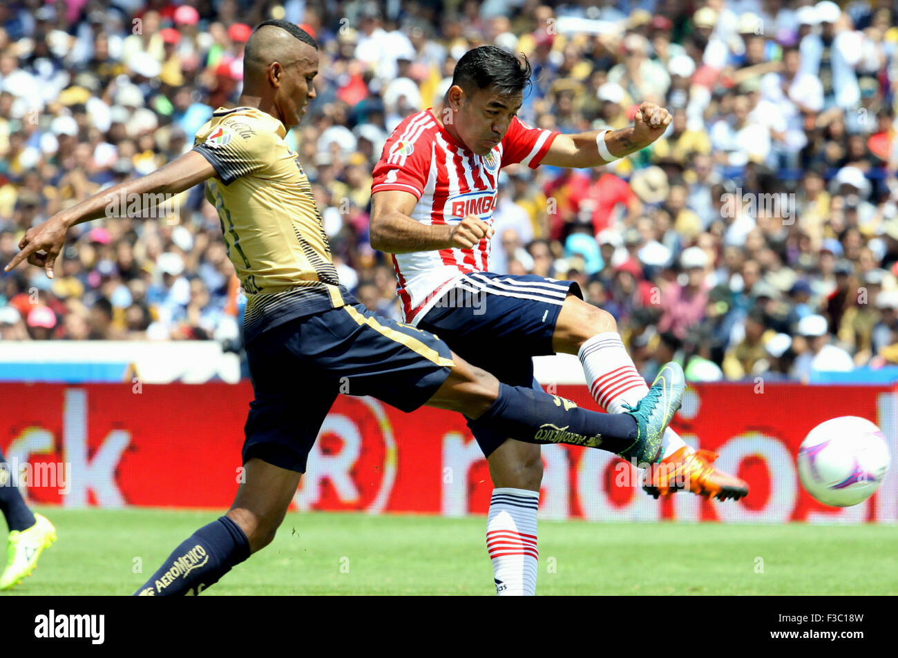 Mexico City, Mexico. 4th Oct, 2015. Pumas del UNAM's Fidel Martinez (L) vies with Chivas' Marco Fabian during the 2015 MX League match held in the University Olympic Stadium, in Mexico City, capital of Mexico, on Oct. 4, 2015. Pumas won by 1-0. © Adriana Perez/Xinhua/Alamy Live News Stock Photo