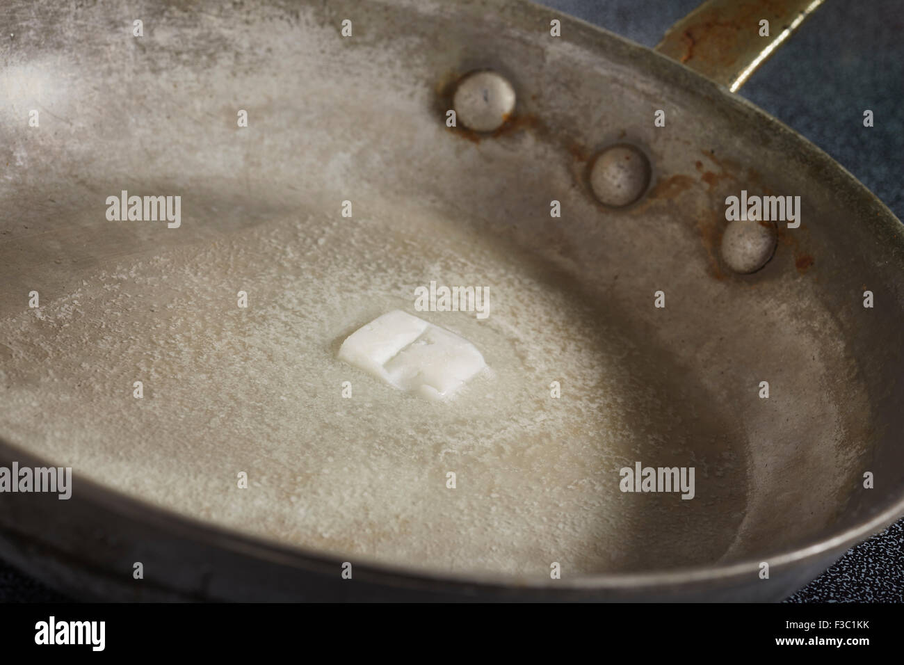 butter melting in a steel skillet Stock Photo