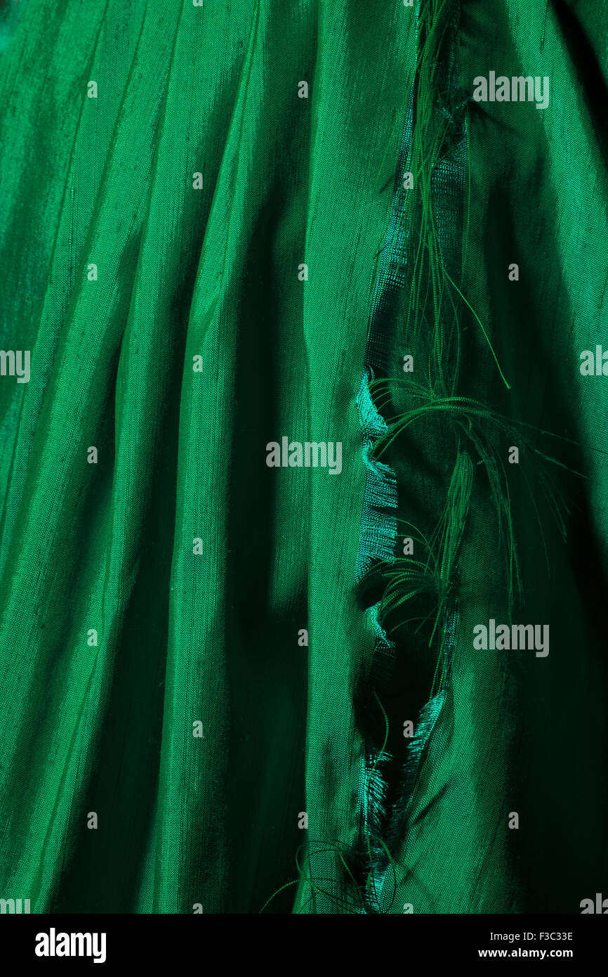 A piece of bright green ripped silk fabric. Stock Photo
