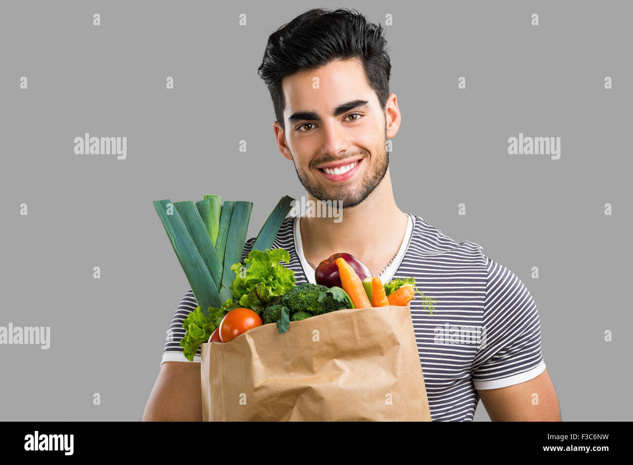 https://c8.alamy.com/comp/F3C6NW/handsome-young-man-carrying-a-bag-full-of-vegetables-isolated-over-F3C6NW.jpg