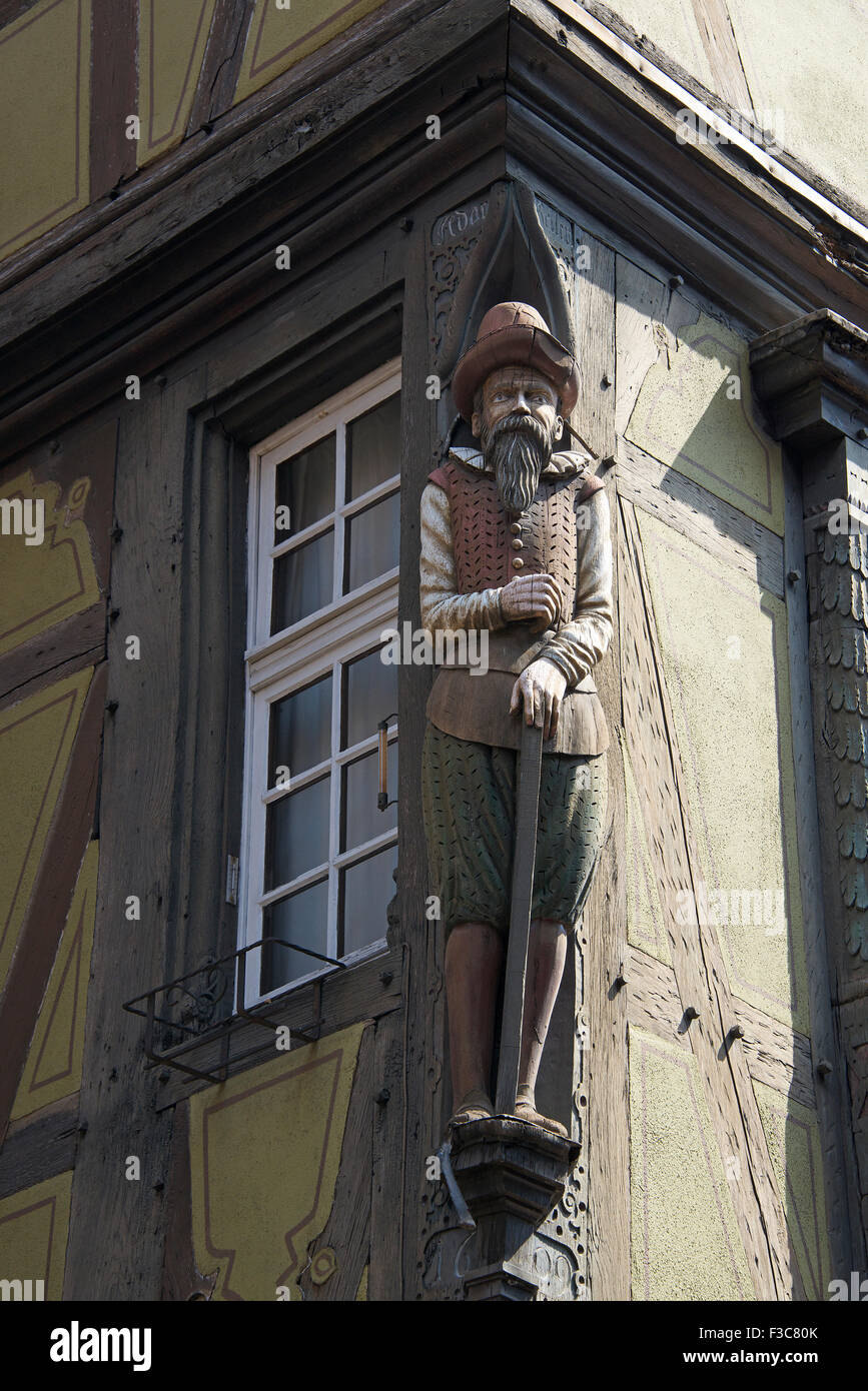 Wooden sculpture of merchant on 16th century Kragen zum House Colmar Alsace France Stock Photo