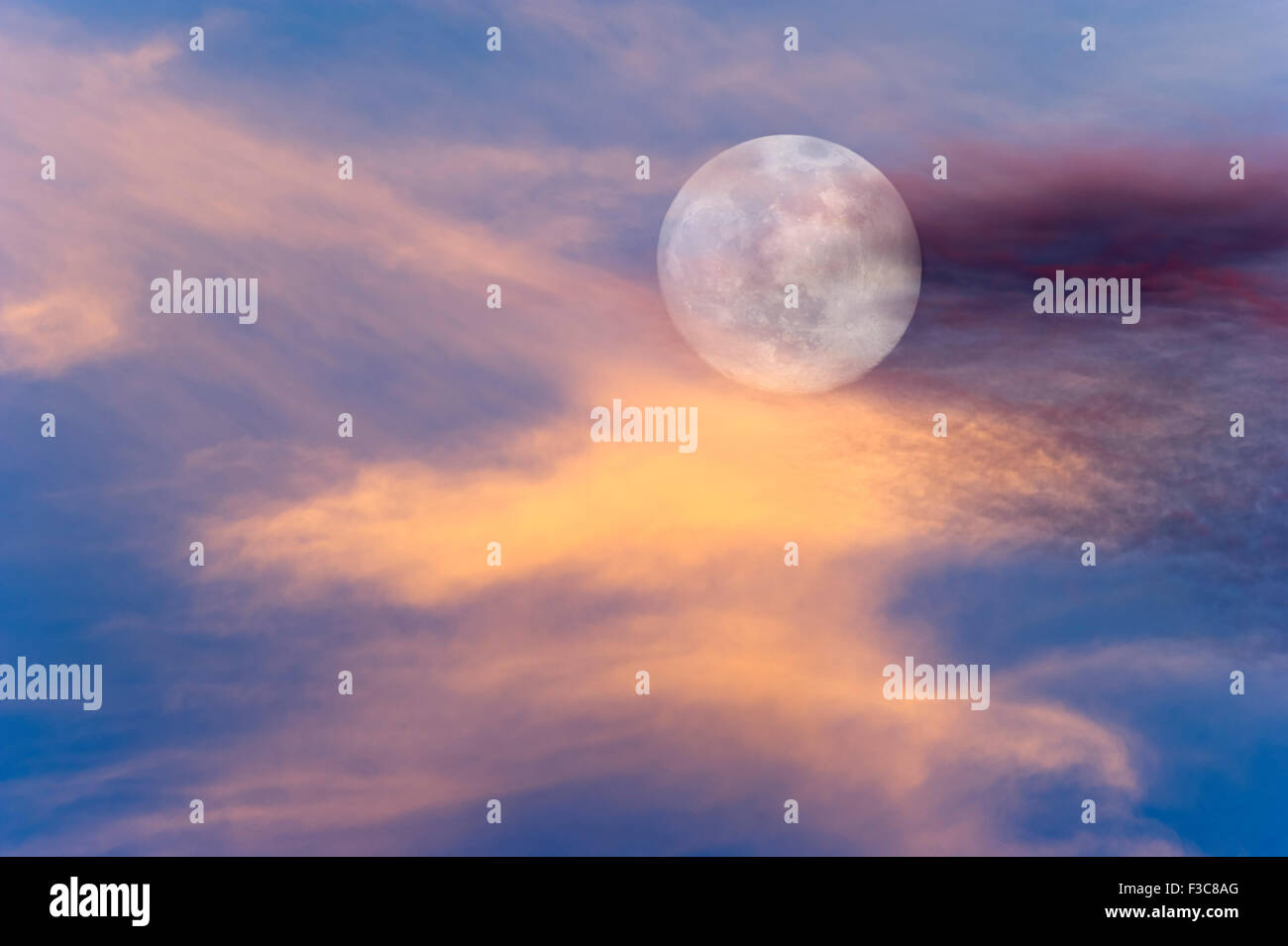 Moon clouds skies is a vibrant surreal scenic of a full moon rising amongst the colorful cloudscape. Stock Photo
