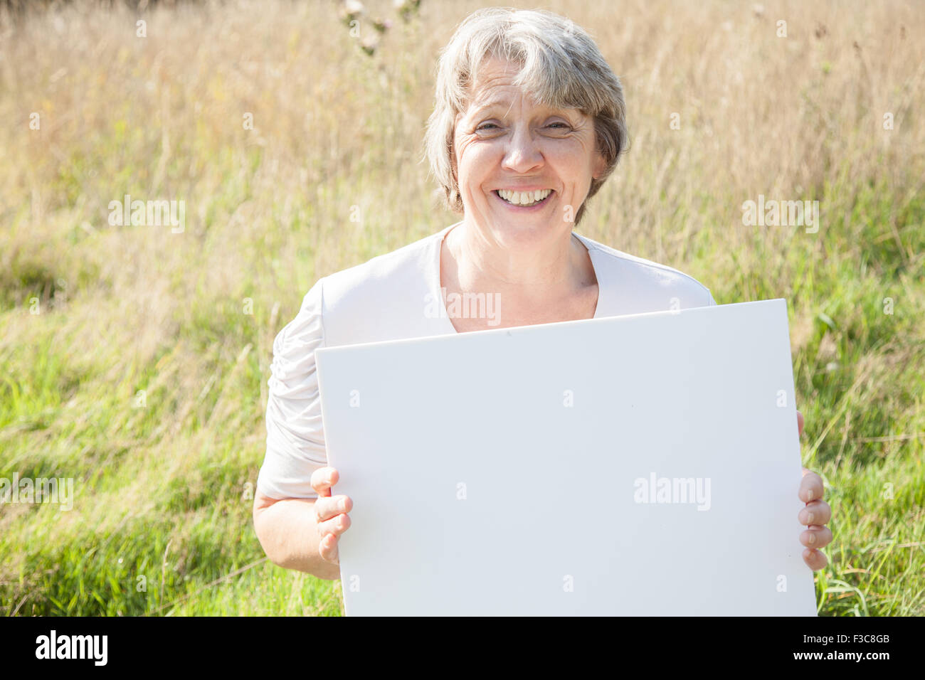 Old age woman holding blank white sign Stock Photo
