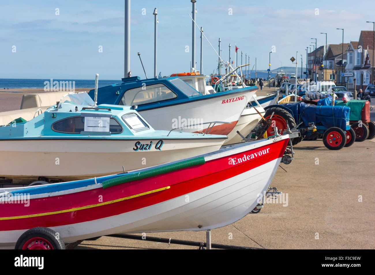 Inshore fishing boats and tractors on their hard standing area on the rebuilt promenade and sea wall at Redcar Cleveland UK Stock Photo