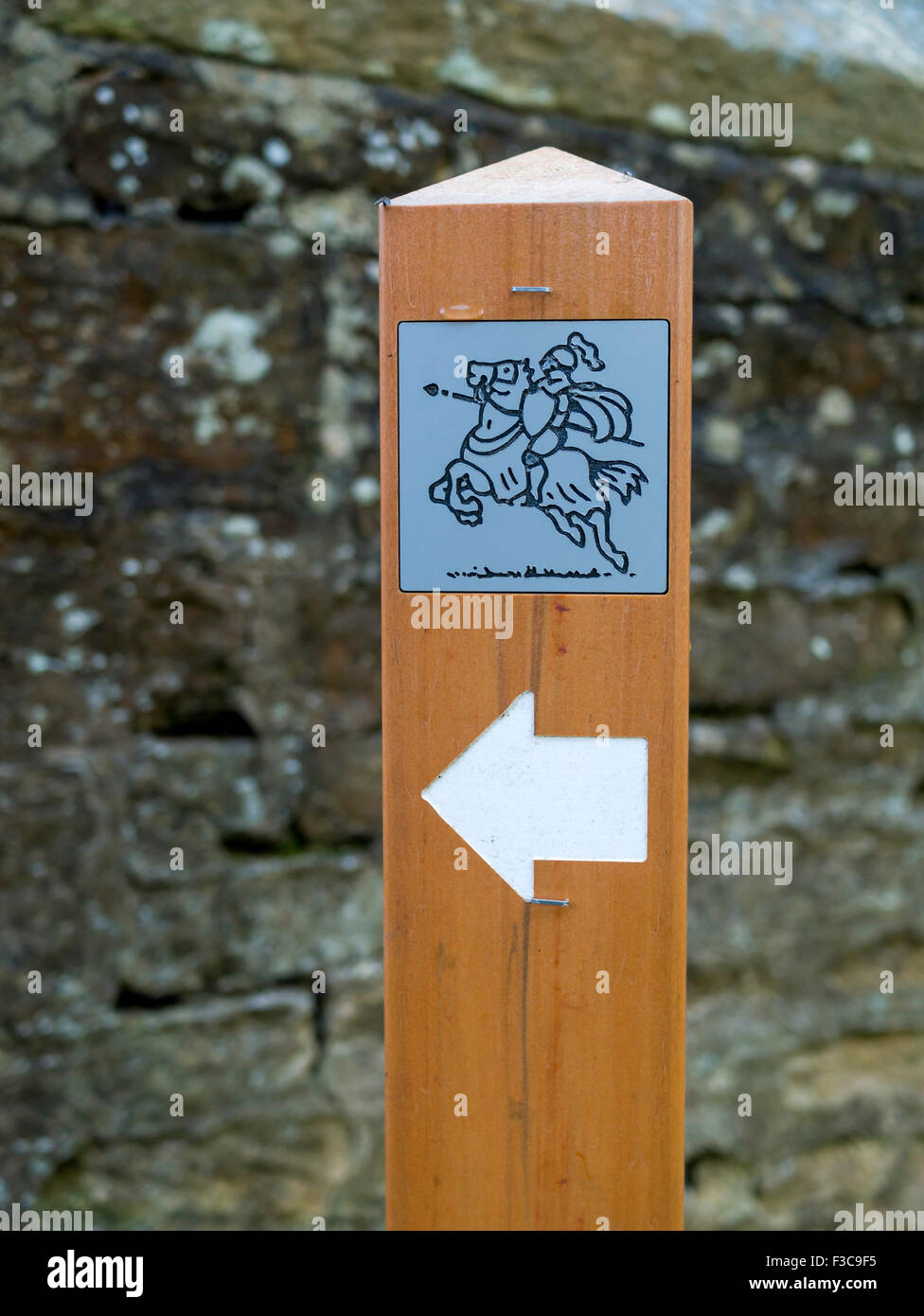 Wooden marker post, showing a jousting knight on a horse on a path in the Deer Park at Auckland Castle Stock Photo