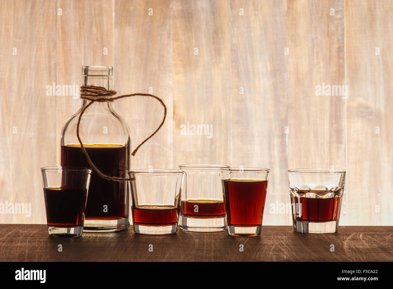 Glass bottle and shots on the wooden background Stock Photo Alamy