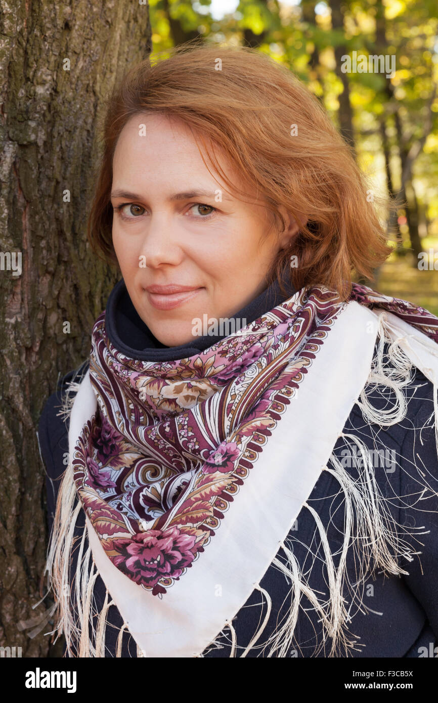 Outdoor autumn portrait of beautiful Young Caucasian woman in traditional Russian Pavloposadskie neck scarf Stock Photo