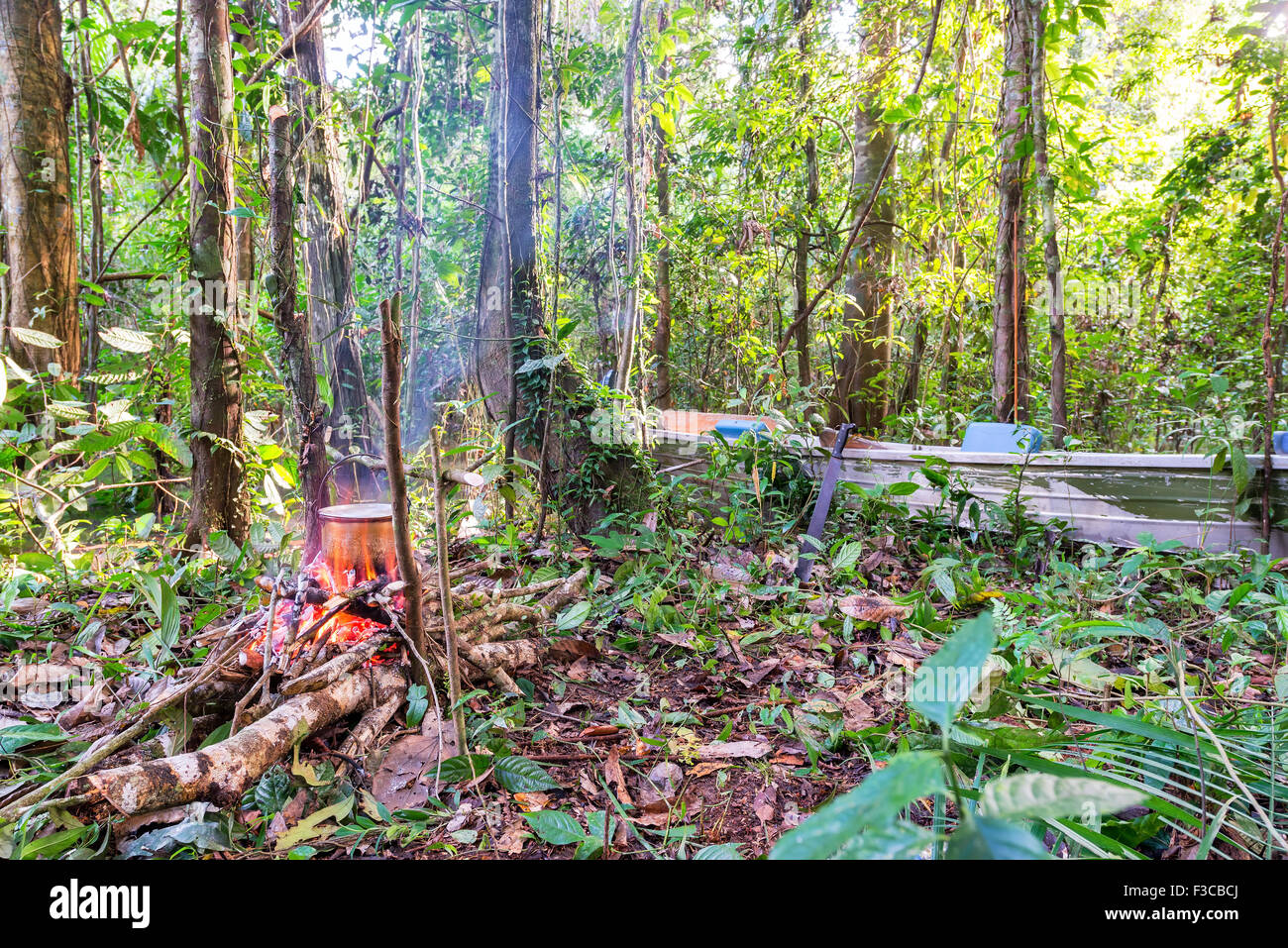 Campfire and boat in the Amazon rain forest near Iquitos, Peru Stock Photo