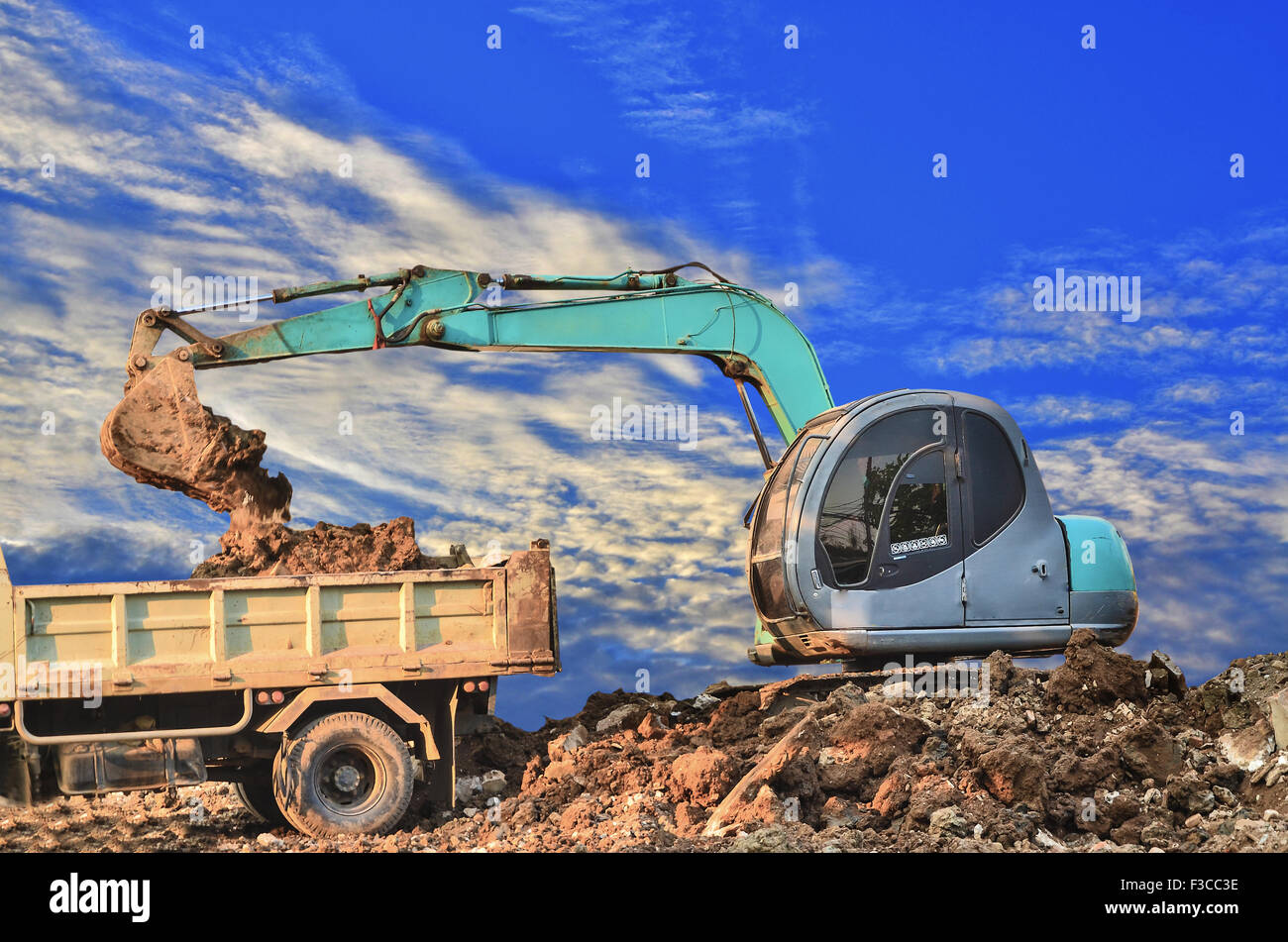 Excavator loading dumper truck tipper in sandpit Stock Photo