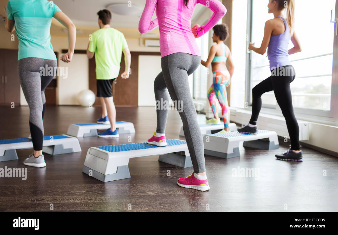 close up of people working out with steppers in gym Stock Photo