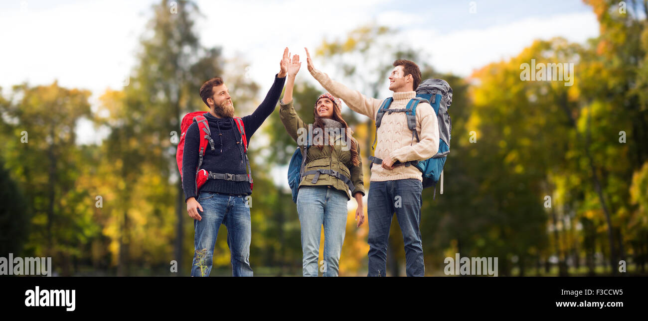 happy friends with backpacks making high five Stock Photo - Alamy