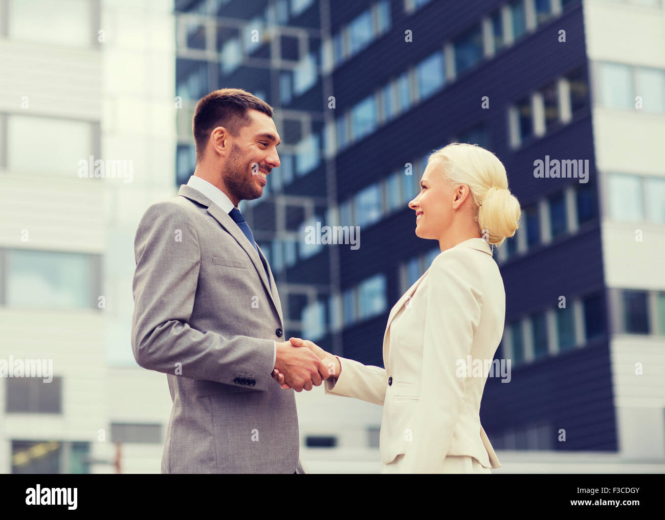 smiling businessmen standing over office building Stock Photo - Alamy