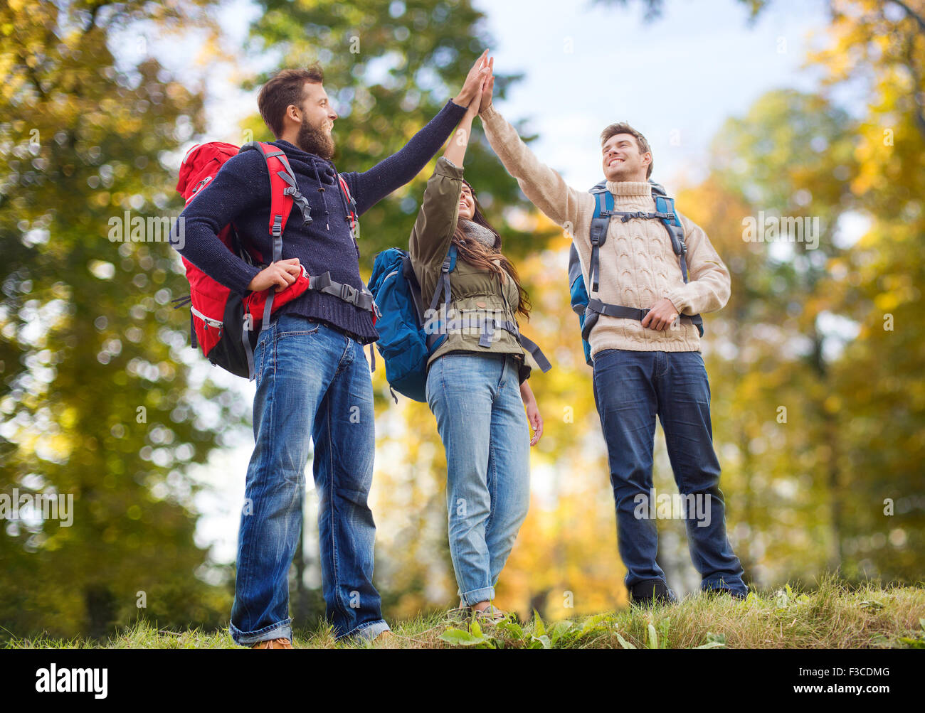 happy friends with backpacks making high five Stock Photo - Alamy