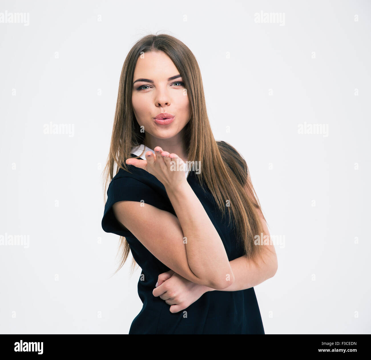 Portrait of a young cute woman blowing kiss at camera isolated on a