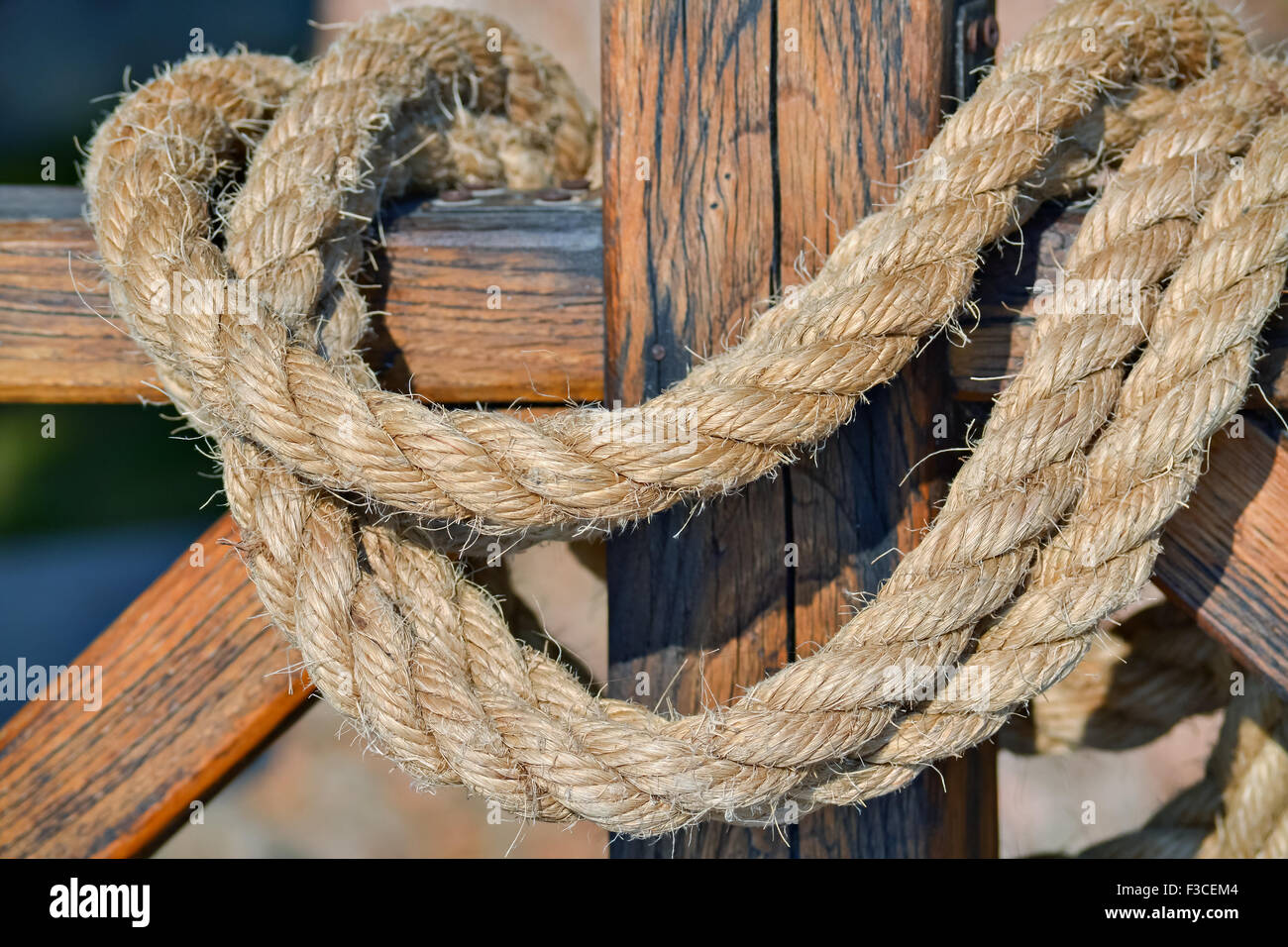 Closeup of a thick hempen rope hanging on a wooden fence Stock Photo - Alamy