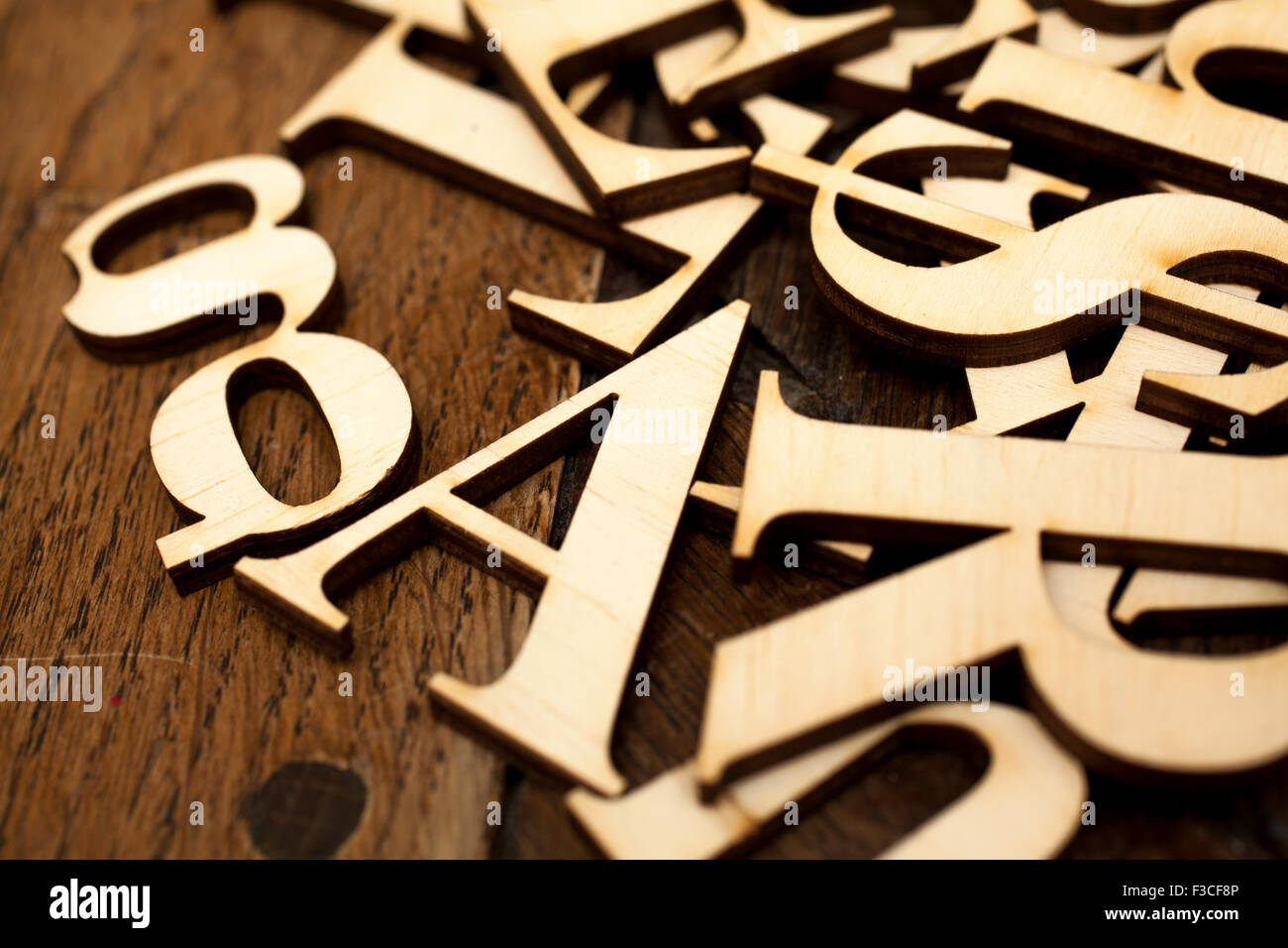 Wooden alphabet letters on old wooden surface with space for your own text. Stock Photo