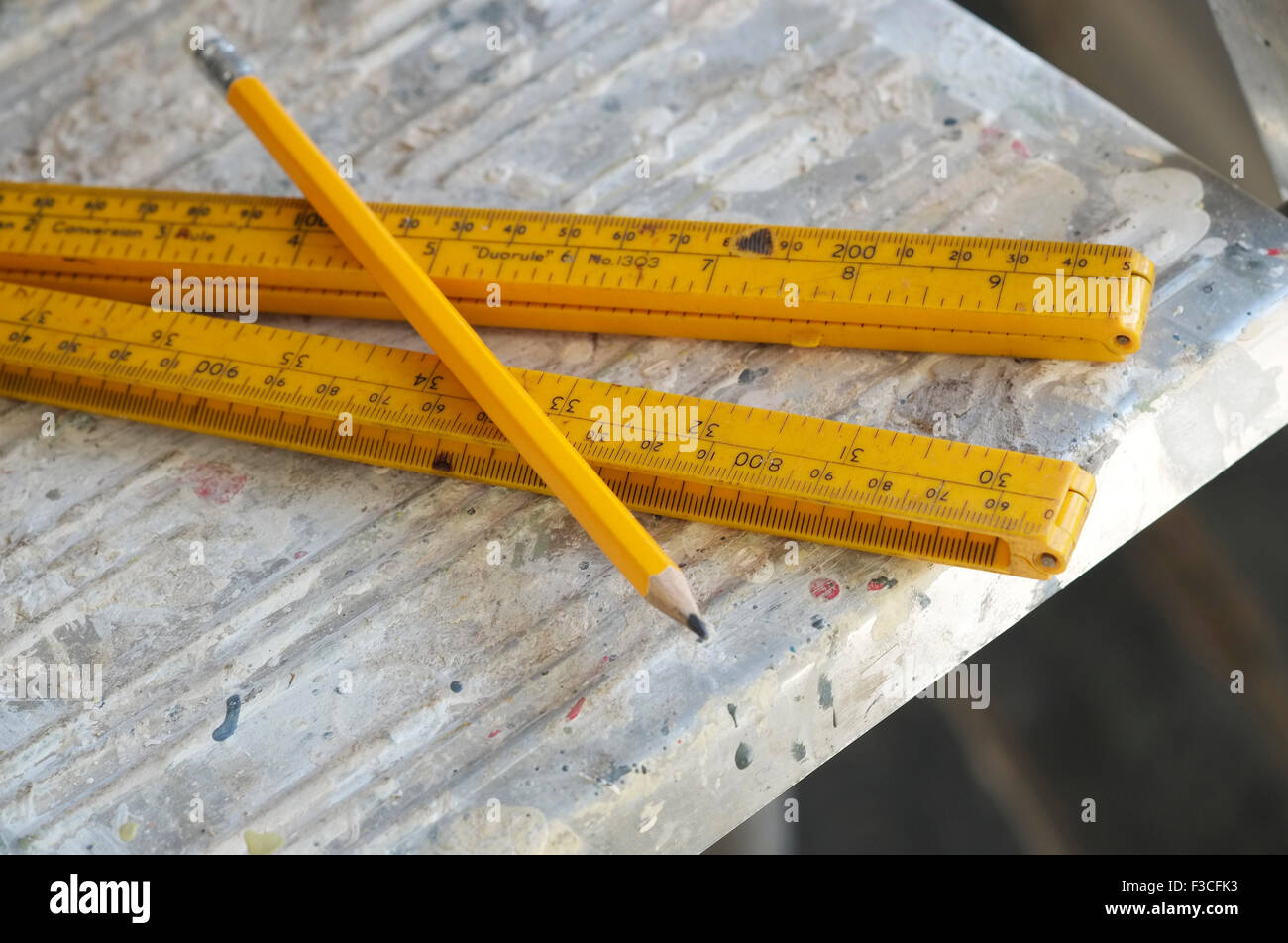 yellow ruler and pencil on top of step ladder Stock Photo