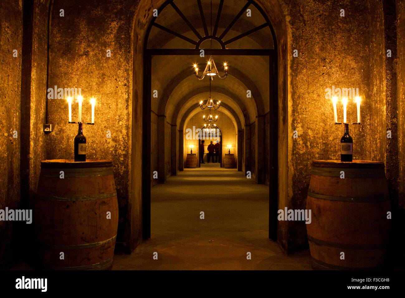 Wine cellar illuminated by candles resting on wine casks Stock Photo