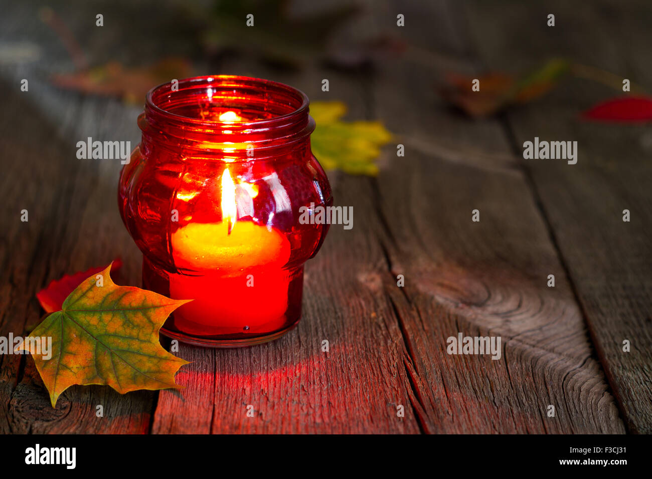 Cemetery red lantern candle with autumn leaves in night concept Stock
