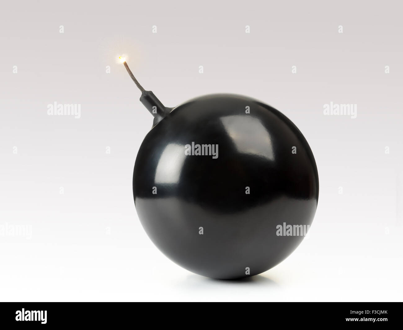 Sphere-shaped black bomb with a burning fuse Stock Photo