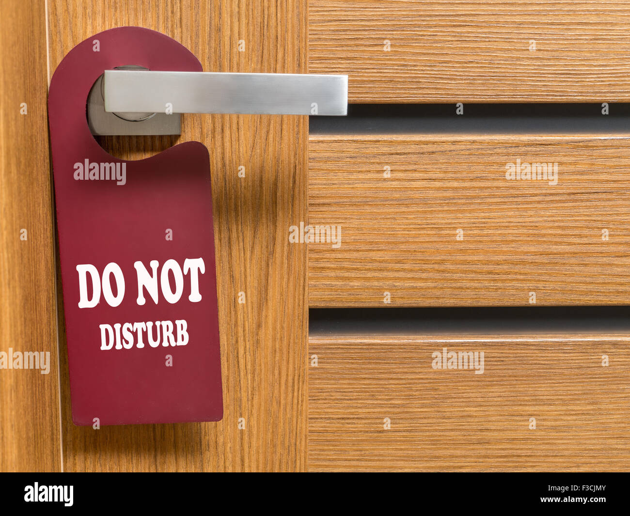 Do Not Disturb door hanger hanging on hotel room door handle Stock Photo