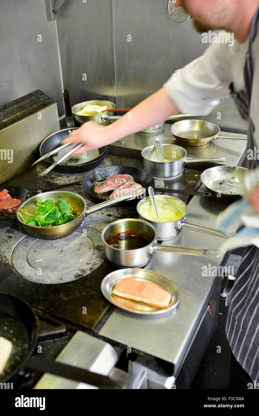 Restaurant chef working busy stovetop Stock Photo