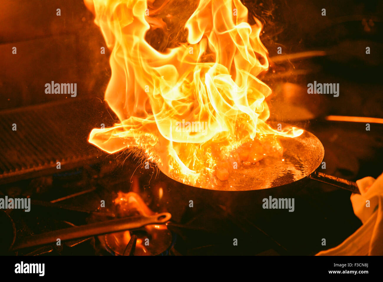 Flaming pan on stove Stock Photo