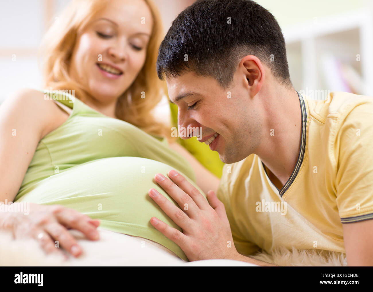 Man strokes belly of his pregnant woman. Careful husband loves his pregnant wife. Stock Photo