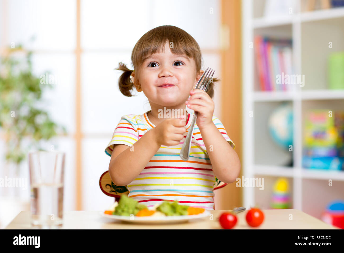 child eats healthy food at home or kindergarten Stock Photo