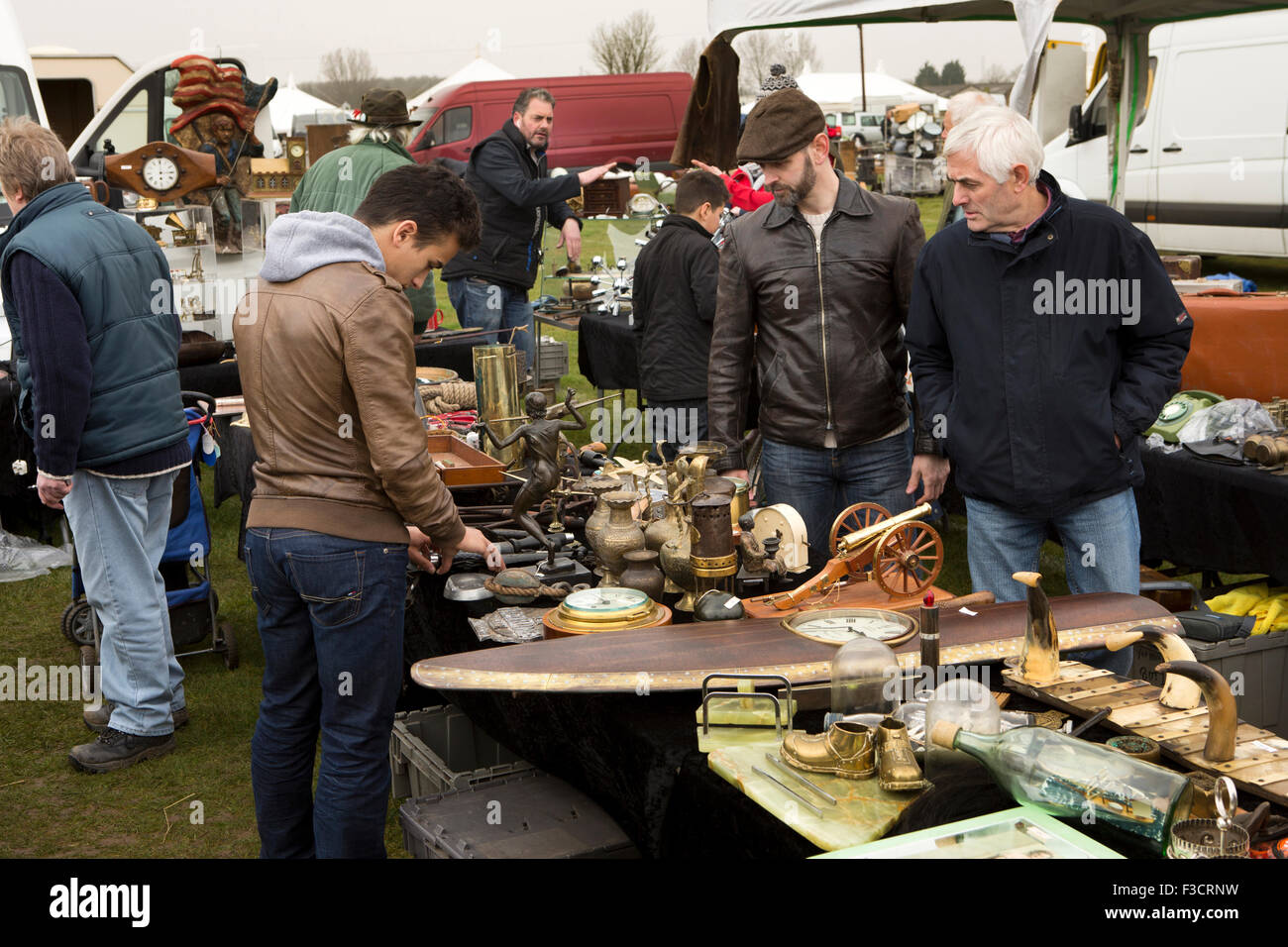 UK, England, Lincolnshire, Lincoln, Antiques Fair, buyers perusing stall including wooden propellor clock Stock Photo