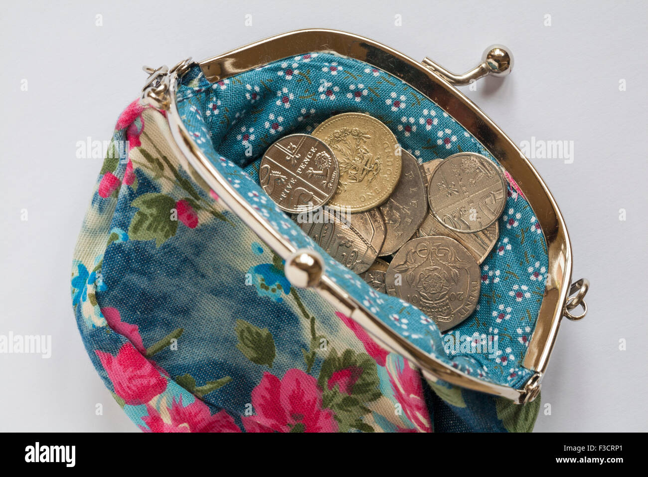 Loose change in pretty flowery purse set on white background Stock Photo