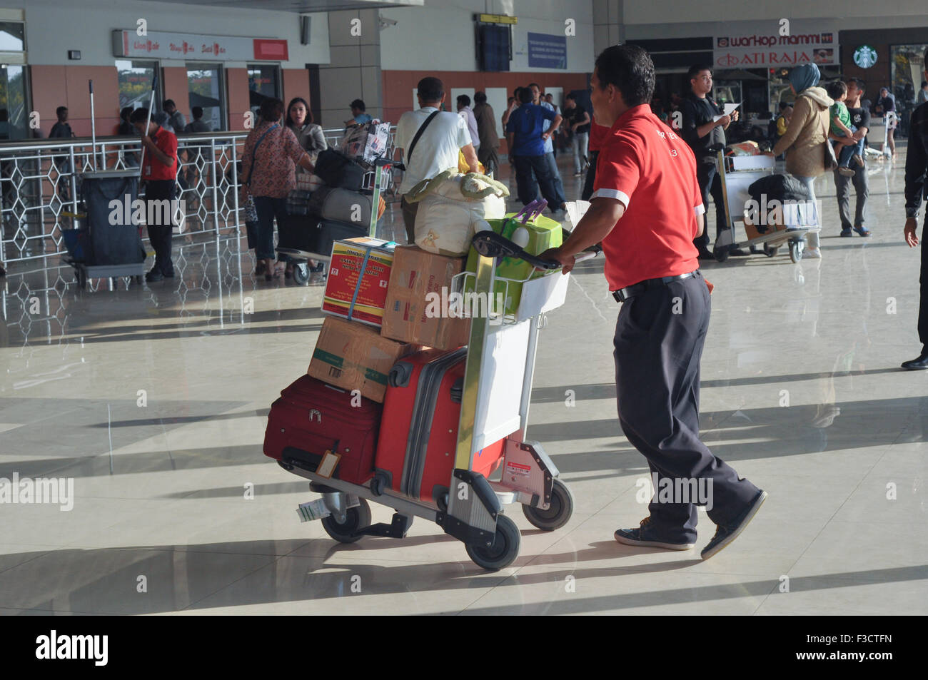 Makassar, Indonesia. 05th Oct, 2015. Porter pushes luggage trolley at Hasanuddin International Airport in Makassar, Indonesia on October 5, 2015.  Hasanuddin Airport is one of the largest airport in Indonesia and become the main hub to eastern Indonesia. Credit:  Yermia Riezky Santiago/Alamy Live News Stock Photo