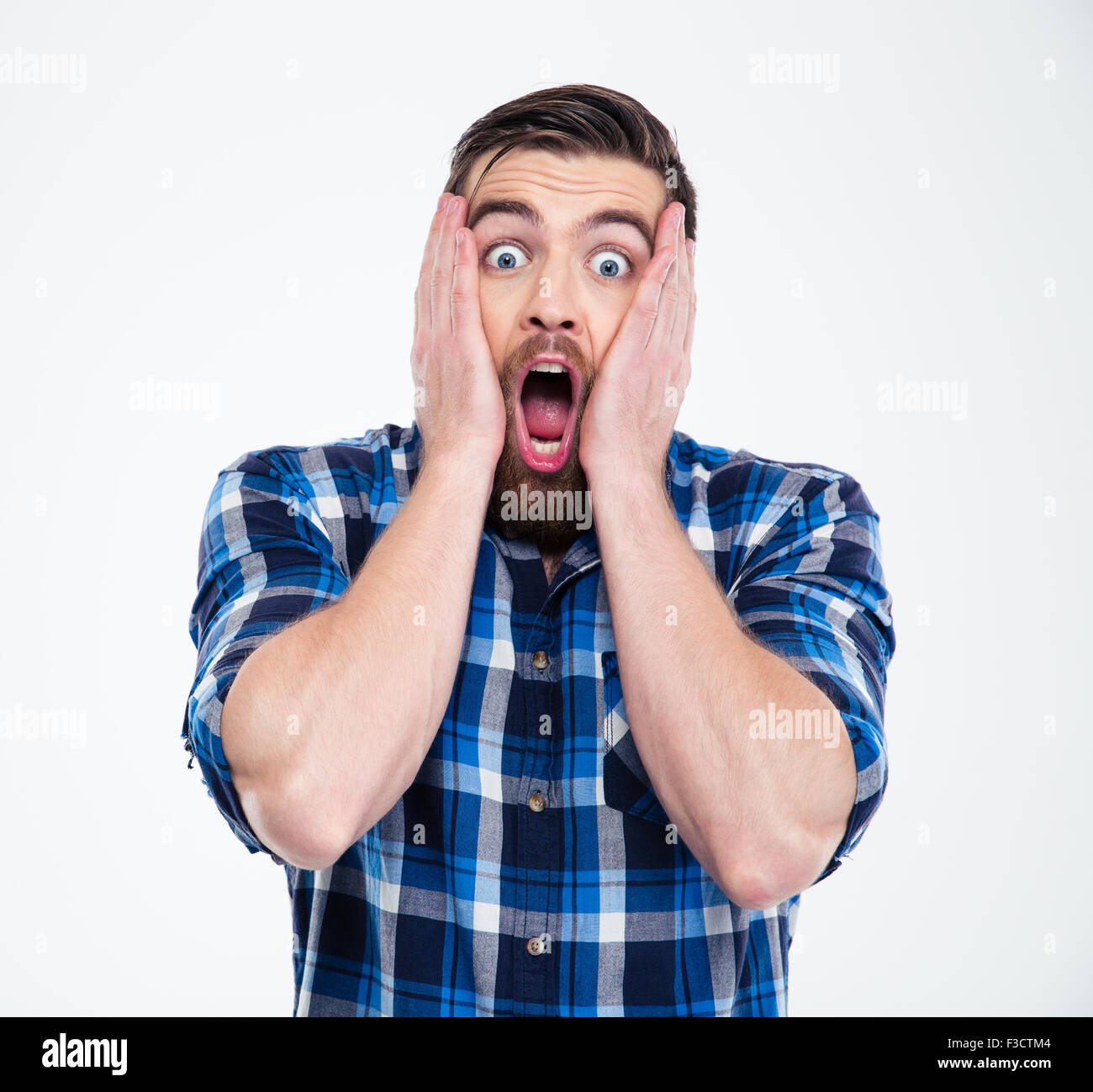 Portrait of a shocked casual man looking at camera isolated on a white background Stock Photo