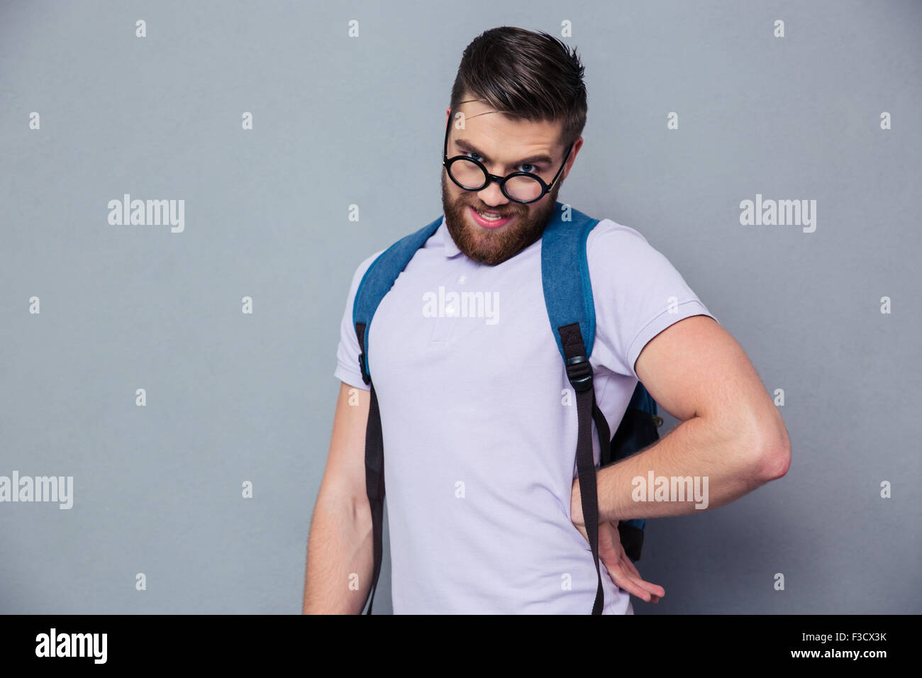 Portrait of a male nerd with funny face standing over gray background Stock Photo