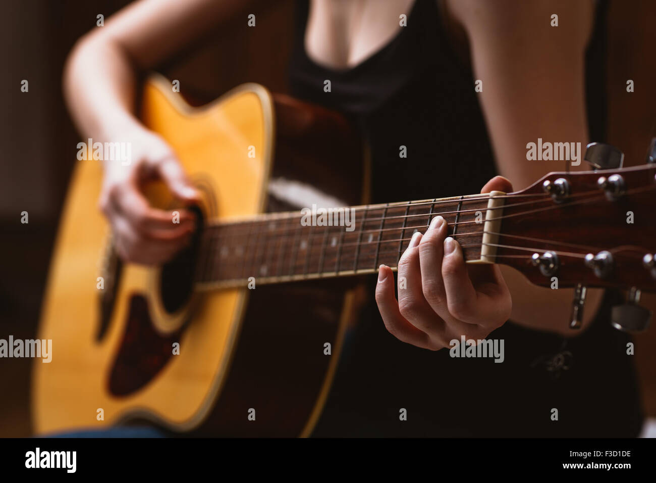 woman's hands playing  acoustic guitar, close up Stock Photo