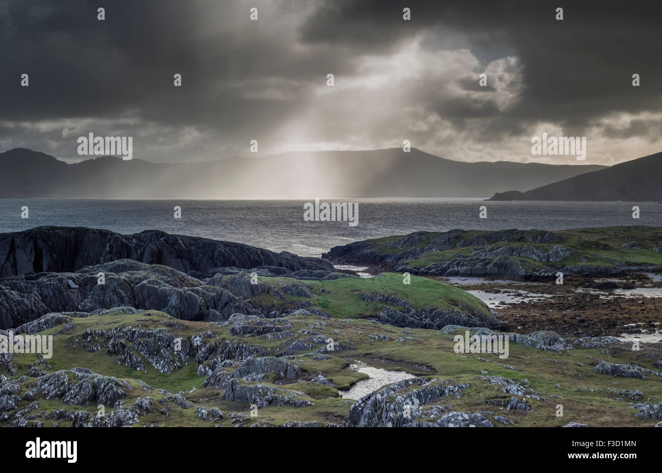 Rain shower and sunburst over Ballydonegan Bay from Garinish looking
