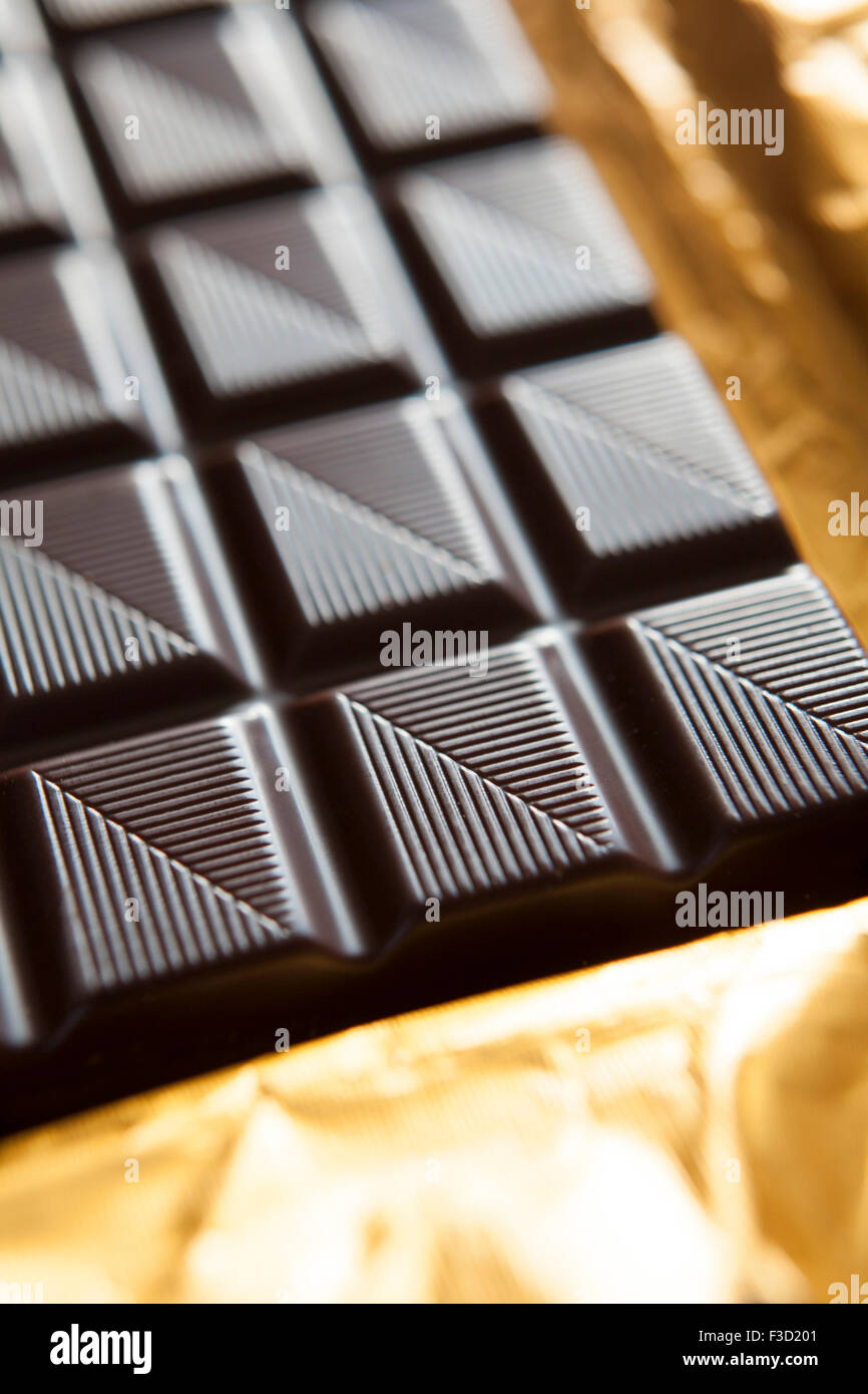 Close Up Of Plain Chocolate Bar On Foil Wrapper Stock Photo
