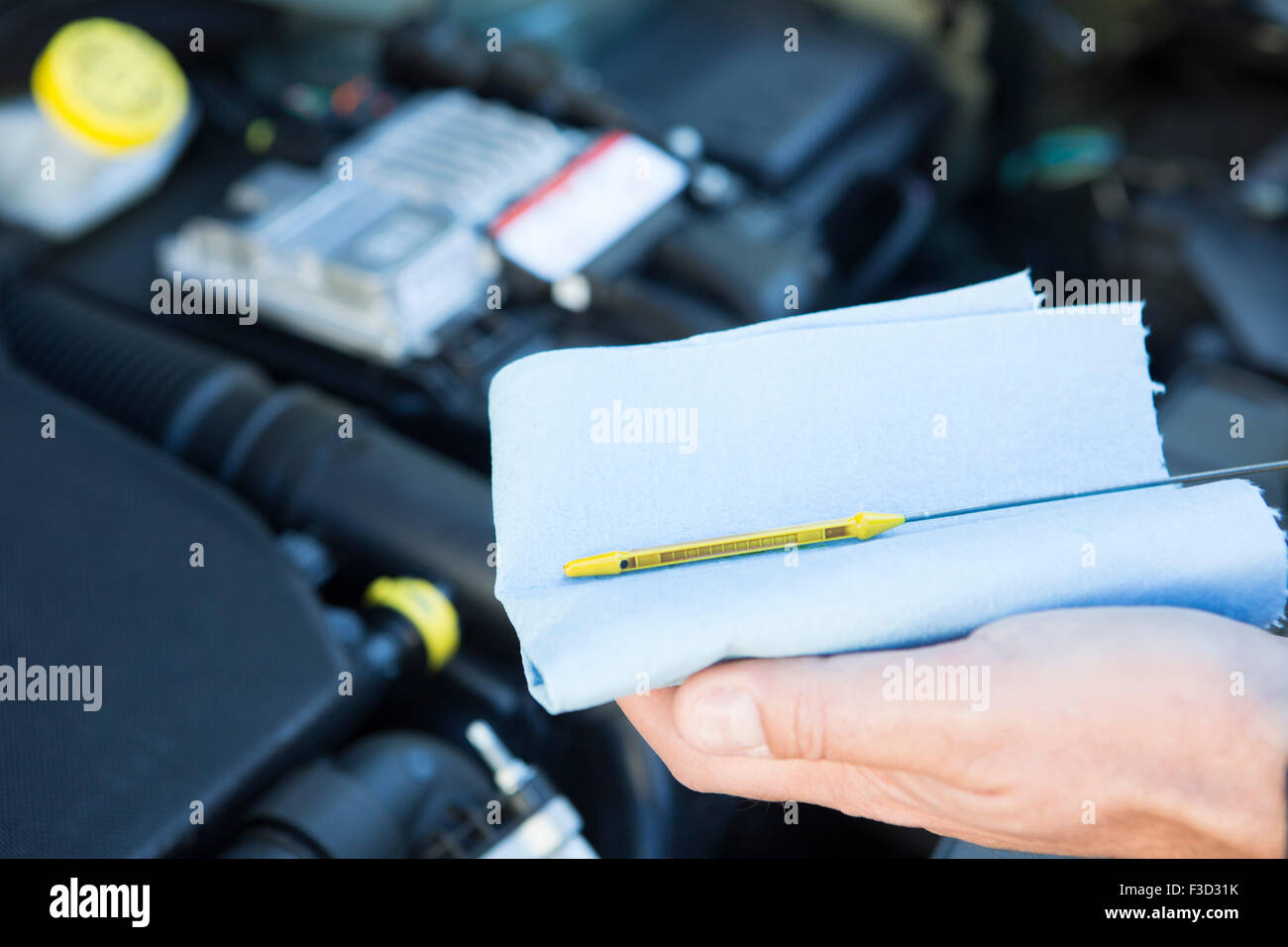 CloseUp Of Man Checking Car Engine Oil Level On Dipstick Stock Photo