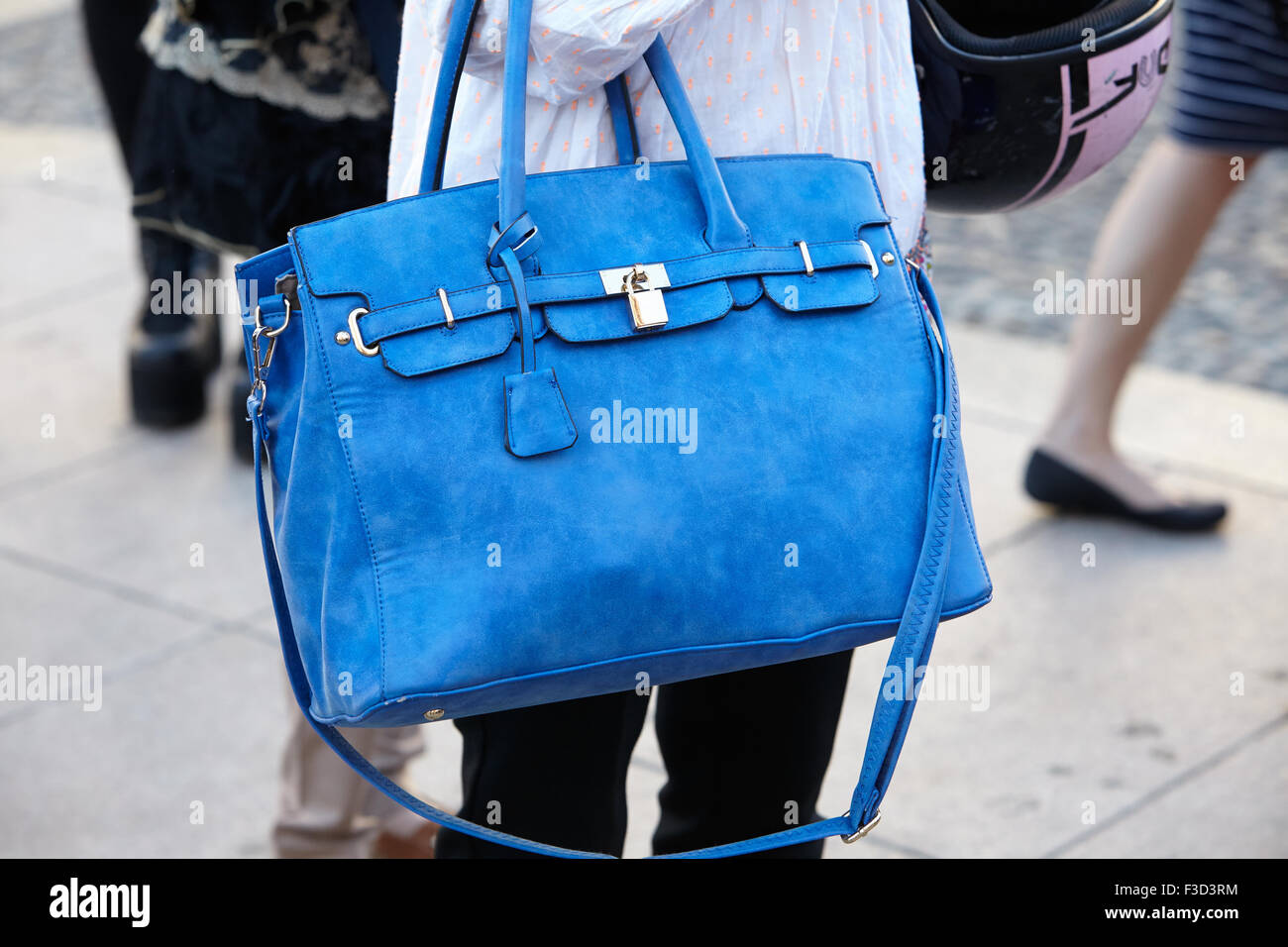 Woman poses for photographers before Cristiano Burani show with blue bag during Milan Fashion Week Day 2 Stock Photo