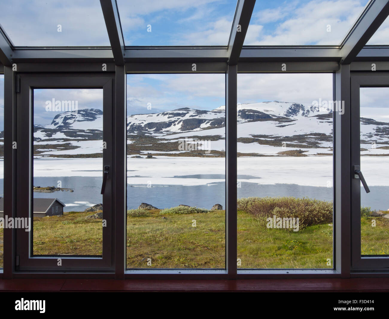 Panorama view from tourist lodge in the Norwegian mountains, lake, patches of snow, distant glacier, Finse Hardangervidda Norway Stock Photo