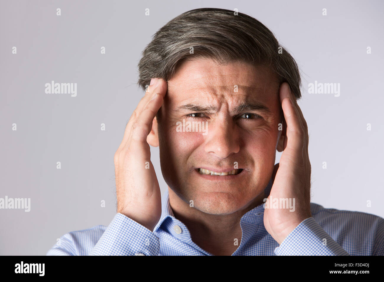Studio Portrait Of Man Suffering With Headache Stock Photo